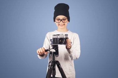 Kameralı neşeli esmer çocuk fotoğrafçı. Stüdyo fotoğrafı.