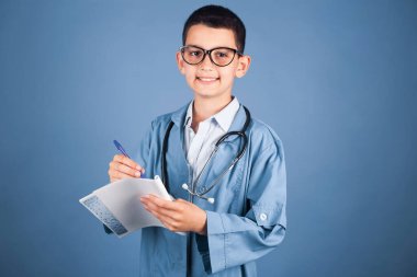 Steteskoplu esmer erkek doktor, tedavi için reçete yazıyor ve reçete yazıyor. Stüdyo fotoğrafı.