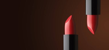 Yakın plan iki güzel kırmızı ruj siyah bir çantada koyu bir arkaplanda