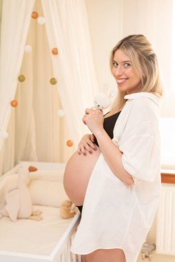 Stüdyoda ilk çocuğunu kutlayan hamile bir kadın.