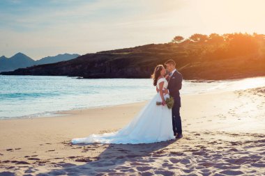 Gelin ve damat, düğünden sonra bir kumsalda birbirlerini düşünüyorlar.