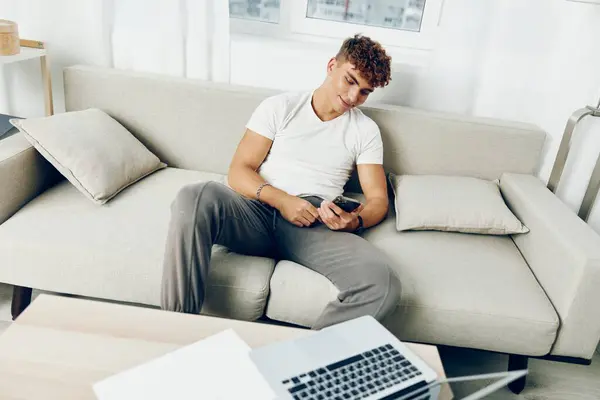 男子室内运动在线家庭小区技术笑模拟使用智能沙发年轻的移动沙发 — 图库照片