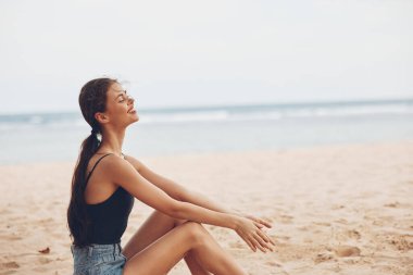 Vücut hatunu deniz seyahati bali tek başına kumsal özgürlüğü doğal moda gülümsemesi güzel dişi kum beyazı genç doğada oturuyor