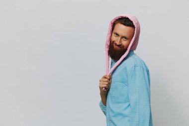 Açık gri arka planda pembe şapkalı komik bir adam. Gülümse ve olumlu duygular besle. Yüksek kalite fotoğraf