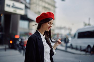 Dişleriyle gülümseyen kadın turist, şehrin tarihini ve kültürünü öğreniyor, şık kıyafetler ve makyaj, bahar yürüyüşü, seyahat, metropol. Yüksek kalite fotoğraf