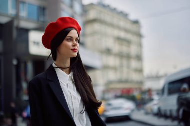 Bir iş kadını şehirde ofis binalarının arka planına, şık kıyafetlere ve makyaja, bahar yürüyüşüne, seyahatlere karşı yürür. Yüksek kalite fotoğraf