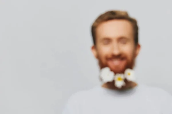 一个穿着白色T恤的滑稽男子的画像 他的胡子上插着花雏菊 背景是白色的 复制的地方 假期的概念和祝贺 高质量的照片 — 图库照片