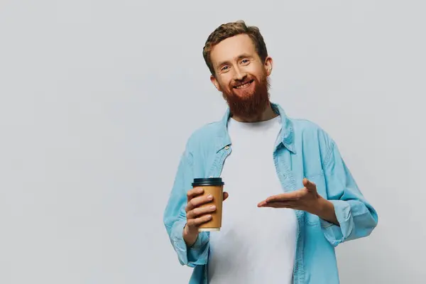 男人嬉皮士一杯咖啡 灰色背景的笑容 蓝色衬衫和白色T恤 高质量的照片 — 图库照片