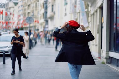 Mutluluk kadını zıplıyor ve kaçıyor, beni takip ediyor ofis binalarının arka planına karşı şehirde yürüyüşler, şık modaya uygun klasik kıyafetler ve makyaj, bahar yürüyüşü, seyahat. Yüksek kalite fotoğraf