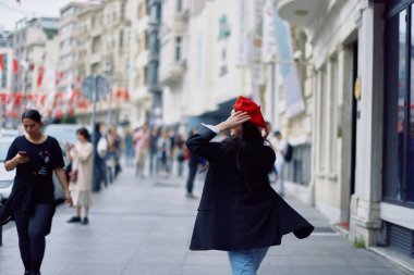 Mutluluk kadını zıplıyor ve kaçıyor, beni takip ediyor ofis binalarının arka planına karşı şehirde yürüyüşler, şık modaya uygun klasik kıyafetler ve makyaj, bahar yürüyüşü, seyahat. Yüksek kalite fotoğraf