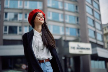 Bir iş kadını şehirde ofis binalarının arka planına, şık modaya uygun vintage kıyafetlere, makyaj malzemelerine, bahar yürüyüşüne, seyahatlere karşı yürüyor. Yüksek kalite fotoğraf