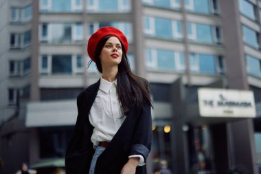 Bir iş kadını şehirde ofis binalarının arka planına, şık modaya uygun vintage kıyafetlere, makyaj malzemelerine, bahar yürüyüşüne, seyahatlere karşı yürüyor. Yüksek kalite fotoğraf