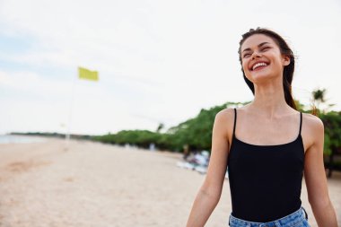 Kadın tatil yeri plajı genç kum torbası kaygısız gülümseyen elbise huzurlu okyanus kıyısı yazı Kafkasya kopya özgürlük doğası