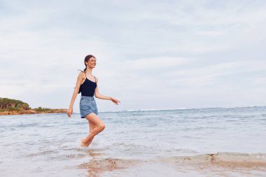 Eğlenceli bir kadın genç aktif bir kadın plaj kızı kumsalda tatil okyanus gülüşü gün batımında koşan seksi bir vücut gün doğumu deniz yolculuğu