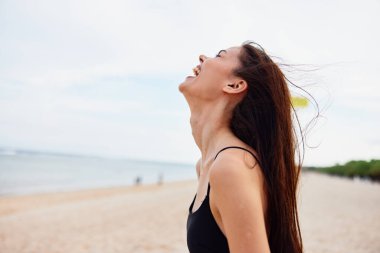 Yetişkin kadın uzay özgürlüğü yaşam tarzı plaj tatili gökyüzü yaz tatili kumsal gülümseme doğa mutluluk tatil genç okyanus tasasız huzurlu kopya