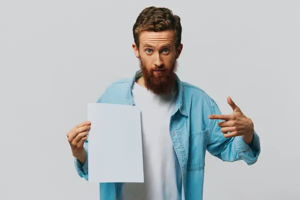 一个成年男性在灰色背景上的画像 手上拿着一张白色的纸 用于设计和文字 复制空间 文字空间 高质量的照片 — 图库照片