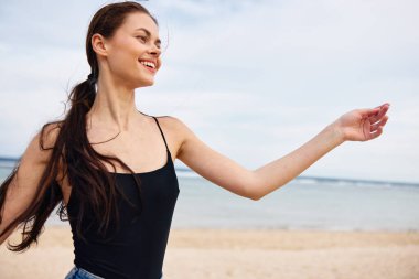 Yaşam tarzı kadın gün batımında gezer gülümseyerek güneşlenir genç mutlu deniz keyfi aktif özgürlük okyanus uçuşları yaz mevsimi pozitif koşu plajı gülümsemesi
