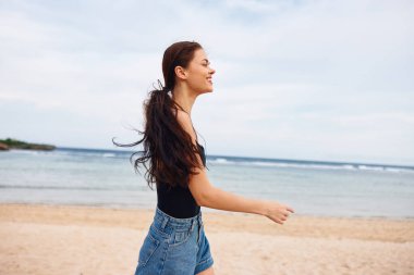 Koşan kadın gülümse, saçlarını rahatlat, hayat tarzı gülümse, yaz mevsimi, gün batımı, deniz aktiviteleri, uzun, tasasız, genç kumsallarda mutlu yürüyüşler.