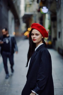 Moda kadın portresi. Kırmızı dudaklı, şık bir turist. Dar bir caddede yürüyor, seyahat ediyor, sinematik renkler, eski tarz, dramatik. Yüksek kalite fotoğraf