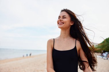Deniz kadını, yaz kumsalı, güzel saçlar, huzurlu gülümseme, okyanus kızı, tatil elbisesi, günbatımı, uzun yetişkin tatili, gülümseyen genç Kafkasyalı.