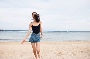 Deniz kıyısında kaygısızca gezen güzel gün batımı doğa yaşam tarzı bikinili mutlu bir yaz tatili aktif genç saçlar.