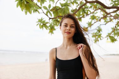 Kadın okyanus açık havada mutluluk plajı tropikal rahatla güneş ışığı gülümse kum torbası genç deniz seyahati yaz tatili güzel tatil