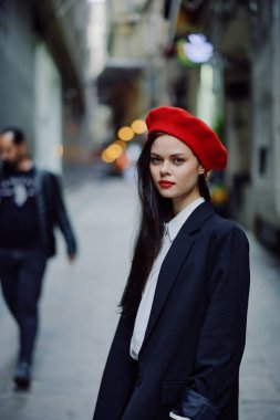 Moda kadın portresi. Kırmızı dudaklı, şık bir turist. Dar bir caddede yürüyor, seyahat ediyor, sinematik renkler, eski tarz, dramatik. Yüksek kalite fotoğraf