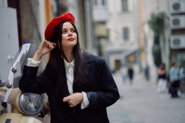 Güzel bir kadın, şehrin caddesinde eski model bir motosikletle dururken gülümsüyor şık bir moda elbisesi, tatili ve seyahati var. Yüksek kalite fotoğraf