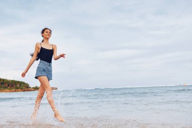 Doğanın gülüşü plaj aktiviteleri gündoğumunda aktif deniz batımı yaşam tarzı yaz saçı tatilinde kıyıda koşan kaygısız, gülümseyen genç mutlu seyahat