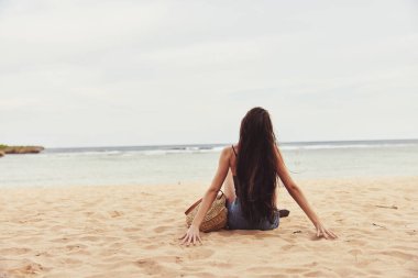 Kadın güneş doğası moda deniz seyahati plajda tek başına oturmak oldukça doğal gülümseme tatili genç tropikal özgürlük çekici beyaz