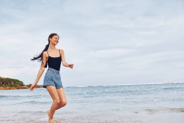 Günbatımı uzay plajı genç seksi gülümseme uzun yürüyüş uzun vücut mutluluğu mutlu yaz seyahati güneş ışığı sırıtan kadın yaşam tarzı