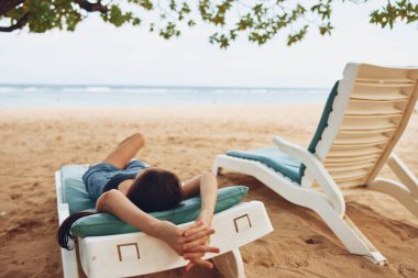 Yaz kadını güneş yatağı maviliği dinlenme yeri yaşam tarzı kumsalda uzanan okyanus insanı tatil denizi gülümseyen Kafkas gevşeme koltuğu