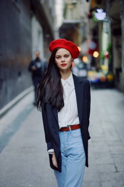 Moda kadın portresi. Kırmızı dudaklı, şık bir turist. Dar bir caddede yürüyor, seyahat ediyor, sinematik renkler, eski tarz, dramatik. Yüksek kalite fotoğraf