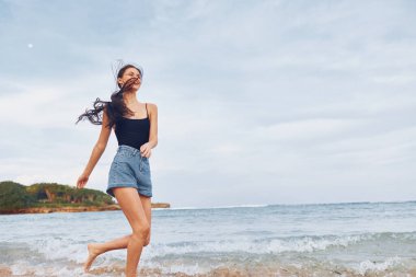 Deniz kadını saçı özgürlük ve yaşam tarzı genç pozitif vücut gülümsemesi mutlu gün batımı aktiviteleri yaz sahili güzel bikinili kadın güzelliği