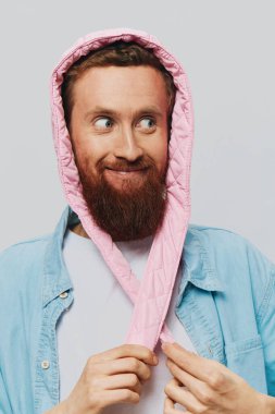 Açık gri arka planda pembe şapkalı komik bir adam. Gülümse ve olumlu duygular besle. Yüksek kalite fotoğraf