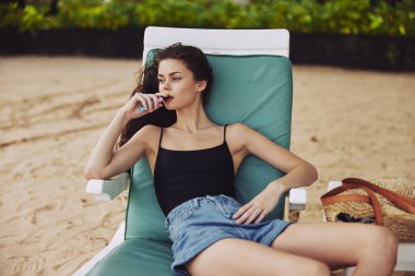 Kız dinleniyor gülümseyen kum okyanusu genç deniz yaşam tarzı tatil koltuğu güneş gözlüğü güneş yatağı plaj insanı Kafkasyalı egzotik tatil gezisi