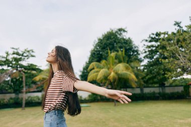 Mutlu kadın gülümseyen yaşam tarzı güzel kız yaz koşusu özgürlük sağlık çim şapka moda günü gülümseme çim parkı tişörtü doğa