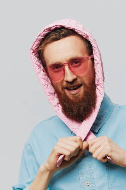 Açık gri arka planda pembe şapkalı komik bir adam. Gülümse ve olumlu duygular besle. Yüksek kalite fotoğraf