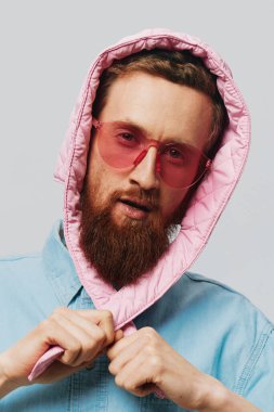 Açık gri arka planda pembe şapkalı komik bir adam. Gülümse ve olumlu duygular besle. Yüksek kalite fotoğraf
