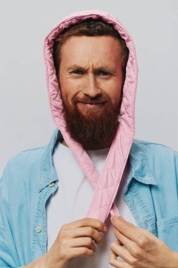 Açık gri arka planda pembe şapkalı komik bir adam. Gülümse ve olumlu duygular besle. Yüksek kalite fotoğraf