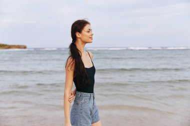 Sahil kadını saç stili kadın denizi açık havada koşuyor. Yazın ücretsiz kopyası. Huzurlu, uzun okyanus ve kaygısız gün batımı.