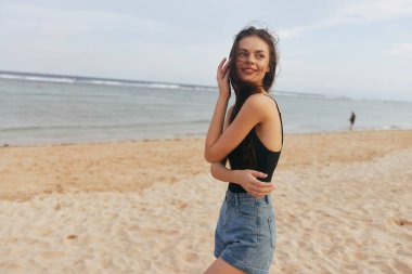 Okyanus kumsalındaki güzel gökyüzü yürüyen güzel kadın gülümseyen yaşam tarzı tropik tatil günbatımı elbisesi gülümseyen kumlu güzel tatil insanı deniz suyu