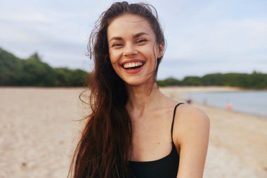 Deniz Kafkasyalı mutlu bir yaşam tarzı plajda yürüyor mutlu bir kız gülümsüyor açık havada ve gülümsüyor su bedava okyanus günbatımının günbatımını kopyalıyor.