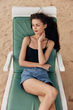 Sakin ol kadın, gülümseyen tropikal mavi insan güneş gözlüğü yaşam tarzı plaj okyanusu genç kumlu çekici güneş kızı deniz yatağında dinleniyor.