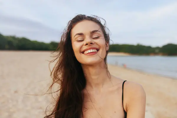 woman peaceful sand caucasian smile sunlight jean beach sunset ocean happiness vacation sun summer young lifestyle smiling sea female enjoyment walking