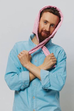 Açık gri arka planda pembe şapkalı komik bir adam. Gülümse ve olumlu duygular besle. Yüksek kalite fotoğraf