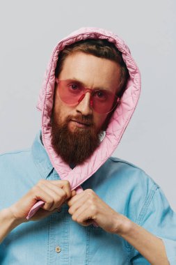 Açık gri arka planda pembe şapkalı komik bir adam. Gülümse ve olumlu duygular besle. Yüksek kalite fotoğraf