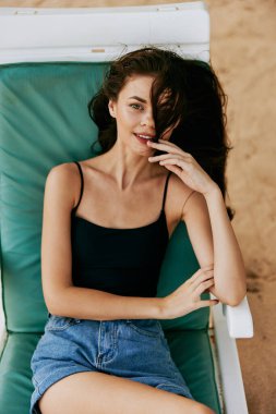 Kum kadın rahatla tatil yeri plajı mavi deniz gülümseyen su tropik oturma tarzı okyanus şapkası dinlenme beyaz mayo