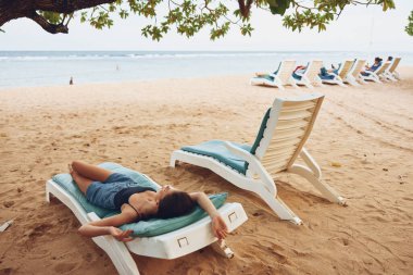 Kadın saçı tatil köyünde güneşlenmenin tadını çıkarır Kafkas Denizi Yazı gülümseyen okyanus uzanan egzotik kum tabakası uzun dinlenen plaj insanı yaşam tarzı dinlenme