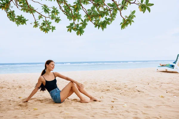 ライフスタイルの女性座って慎重な笑顔ビーチ自然旅行モデル休日砂バック女性の海の眺め人セクシーな美しさの自由美しい — ストック写真